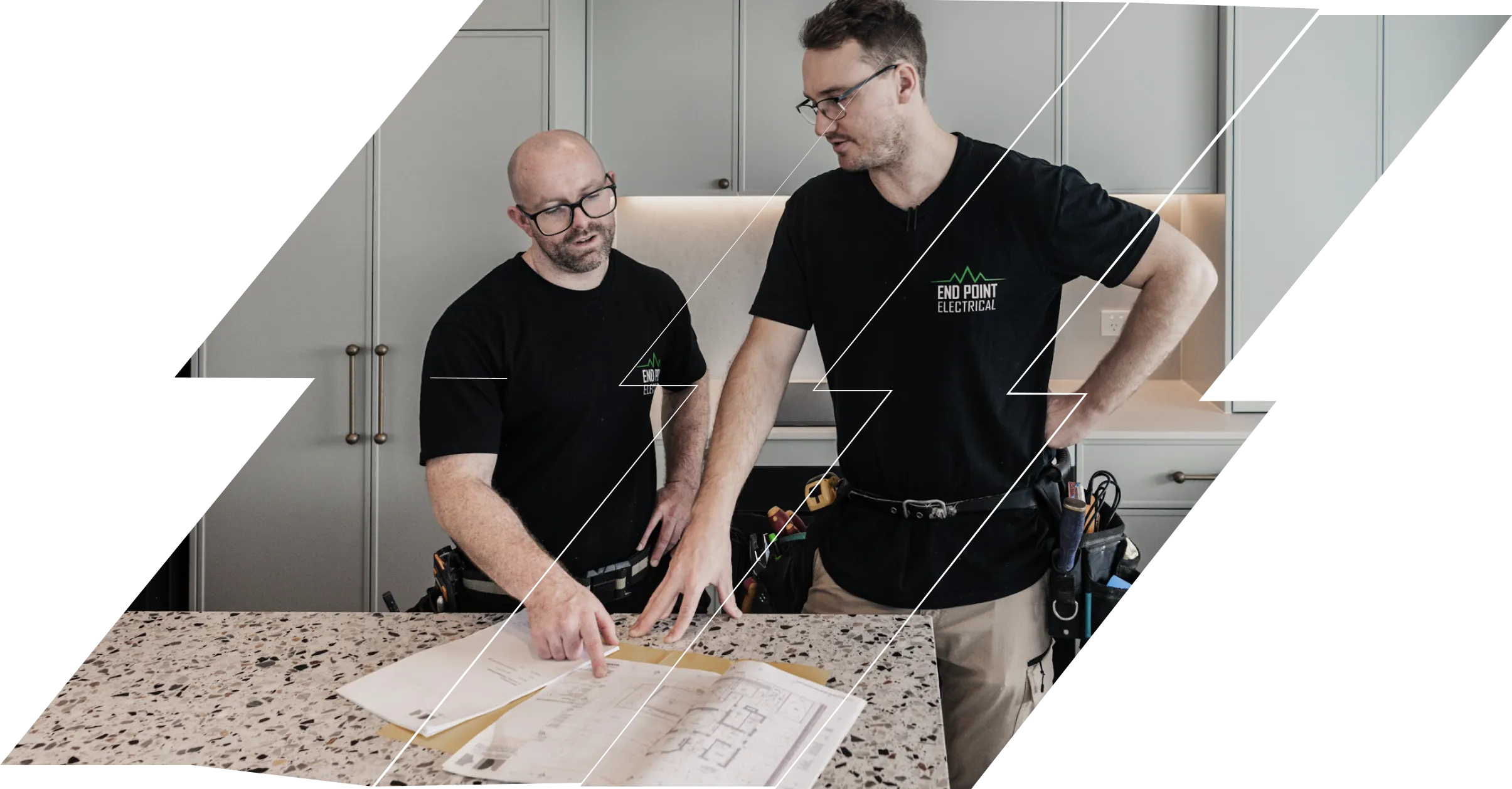Two End Point Electrical electricians reviewing house plans on a kitchen benchtop